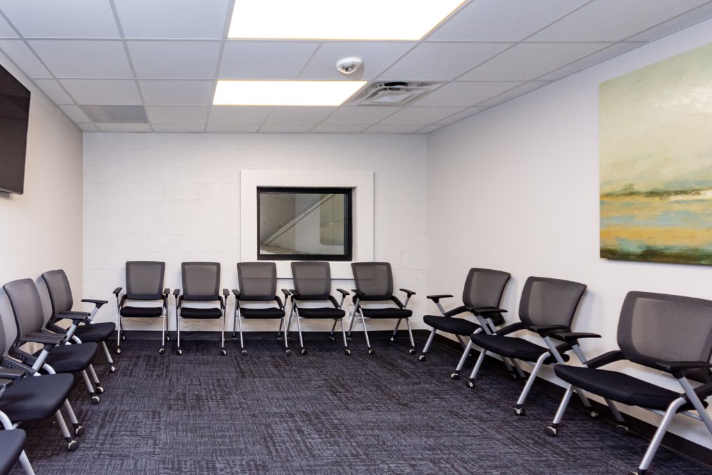 A group therapy room with black chairs and modern decor.