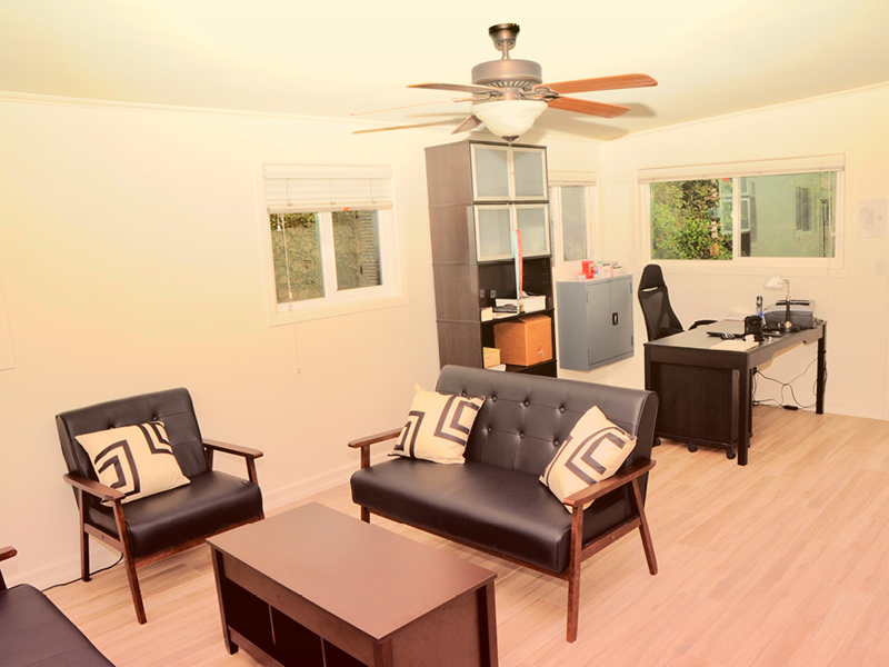 Office space with black leather seating and a desk.