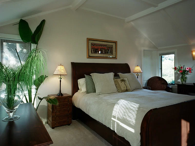 Bedroom with large bed, wooden furniture, and soft natural lighting