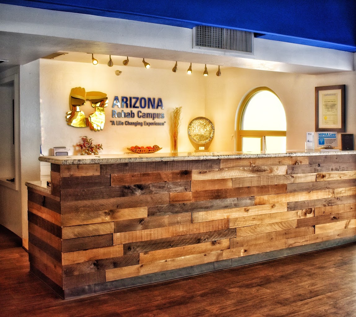 Rehab center reception desk with rustic wood and signage.