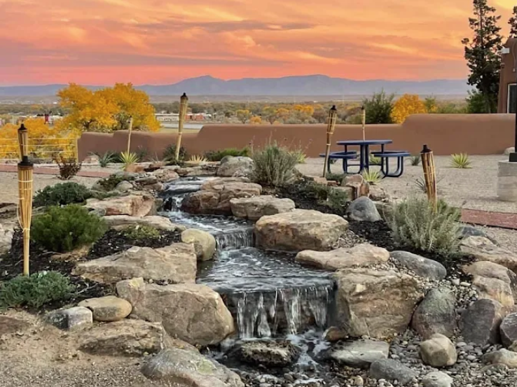 Rock waterfall with torches and sunset view over the mountains