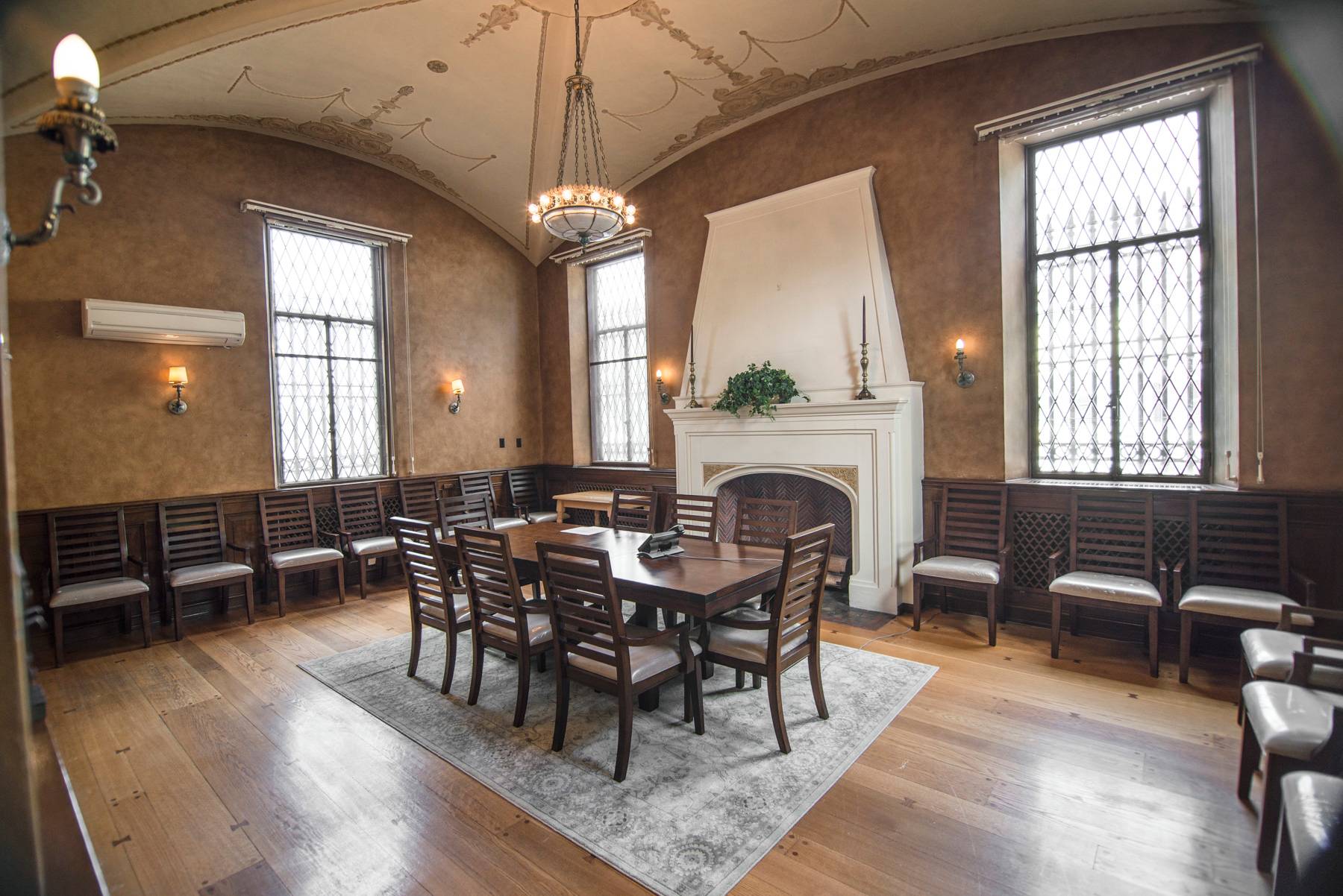 Elegant room with long table, fireplace, and ornate ceiling