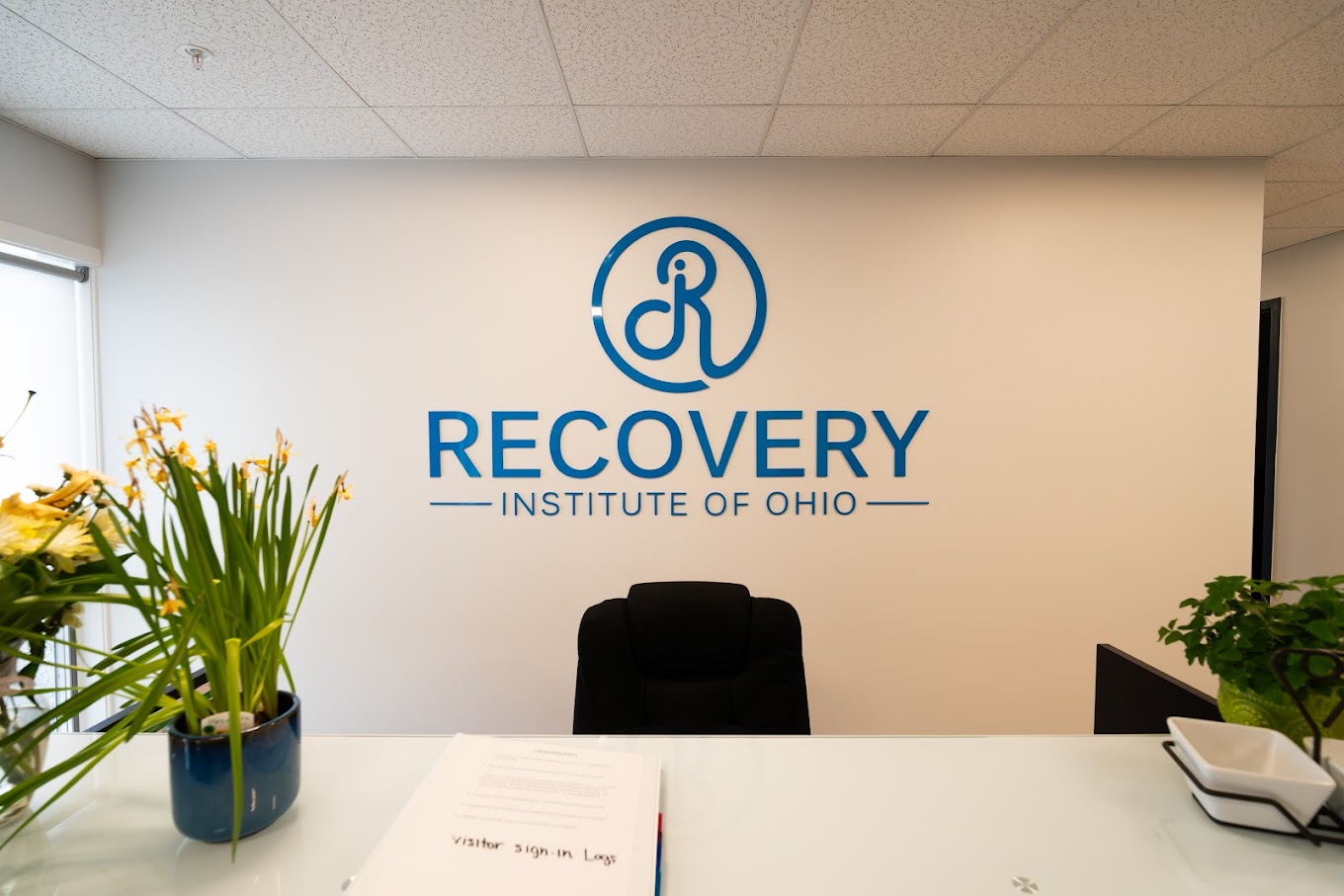Reception desk with large Recovery Institute of Ohio logo behind it.