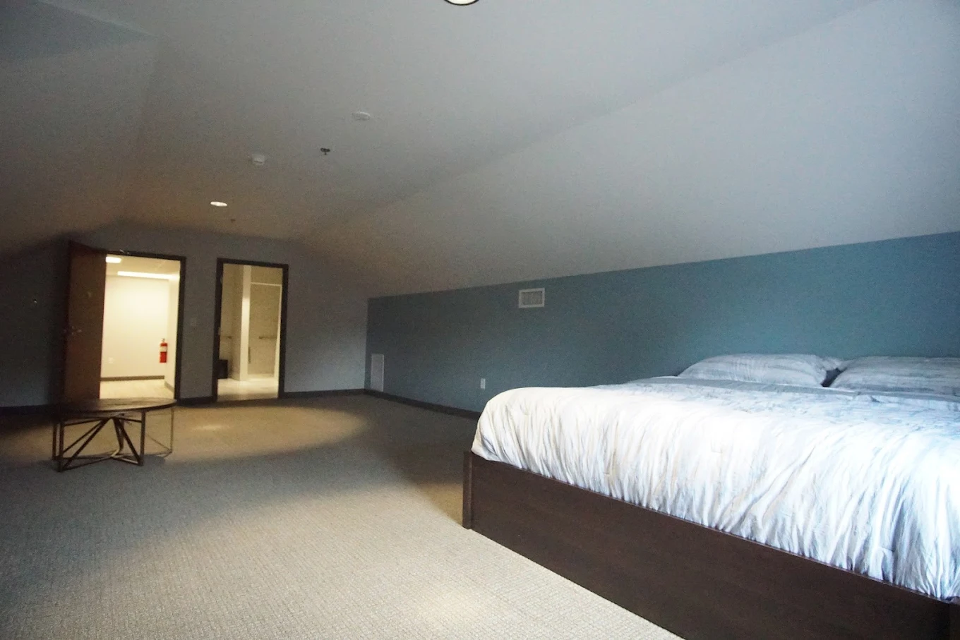 Large bedroom with bed, nightstand, and open doorway