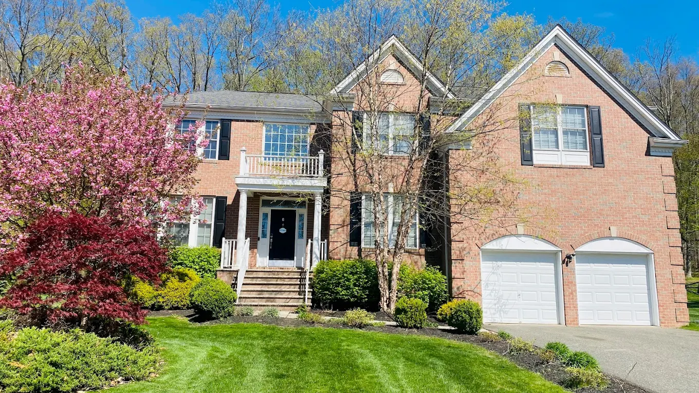 Brick residential home with landscaped yard and two-car garage.