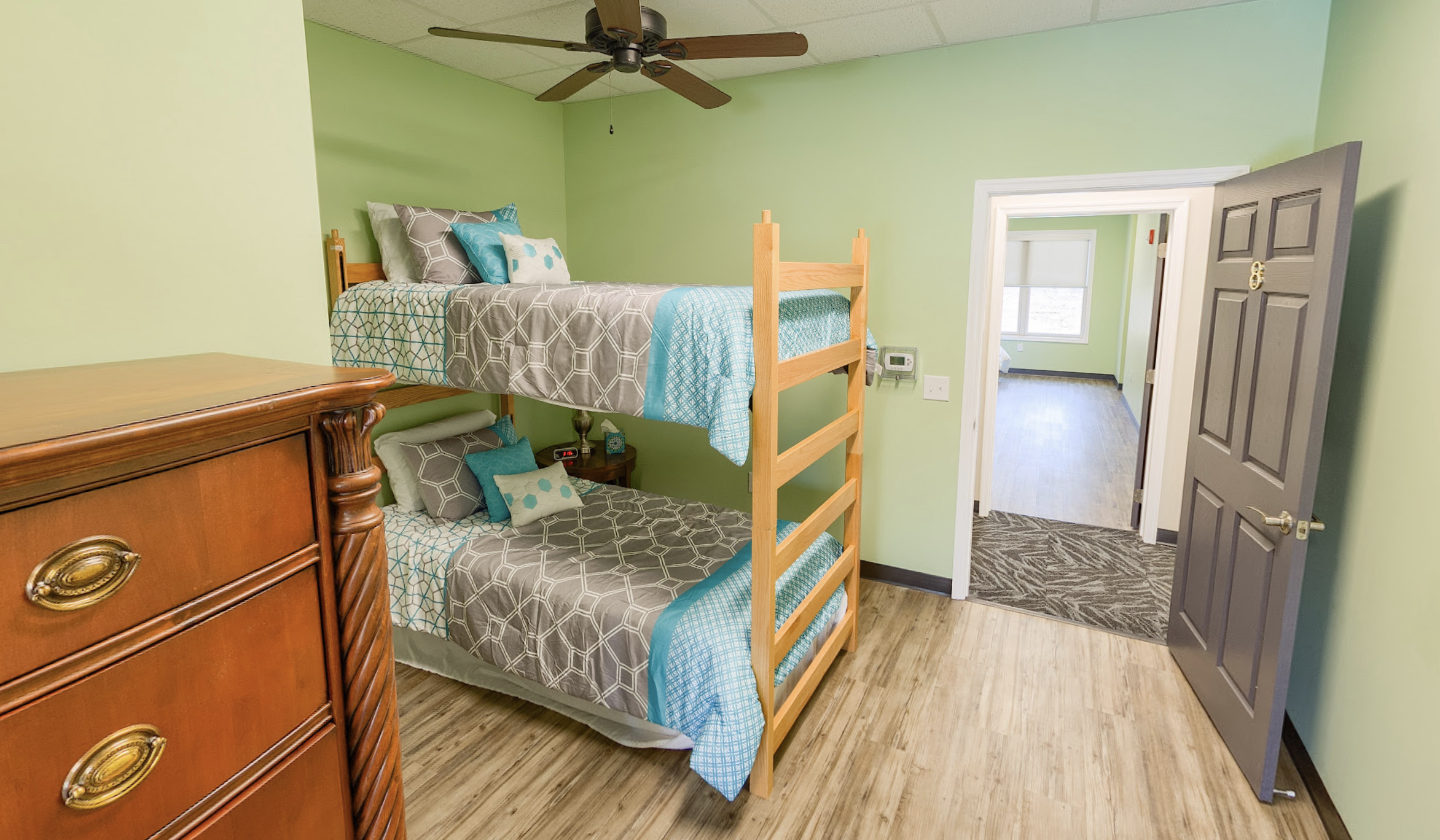 Shared bedroom with wooden bunk beds and ceiling fan