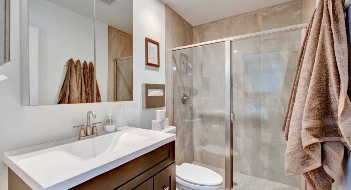 Bathroom with glass shower and single-sink vanity