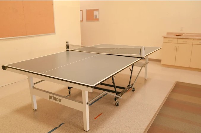 Ping pong table in bright recreation room with kitchenette