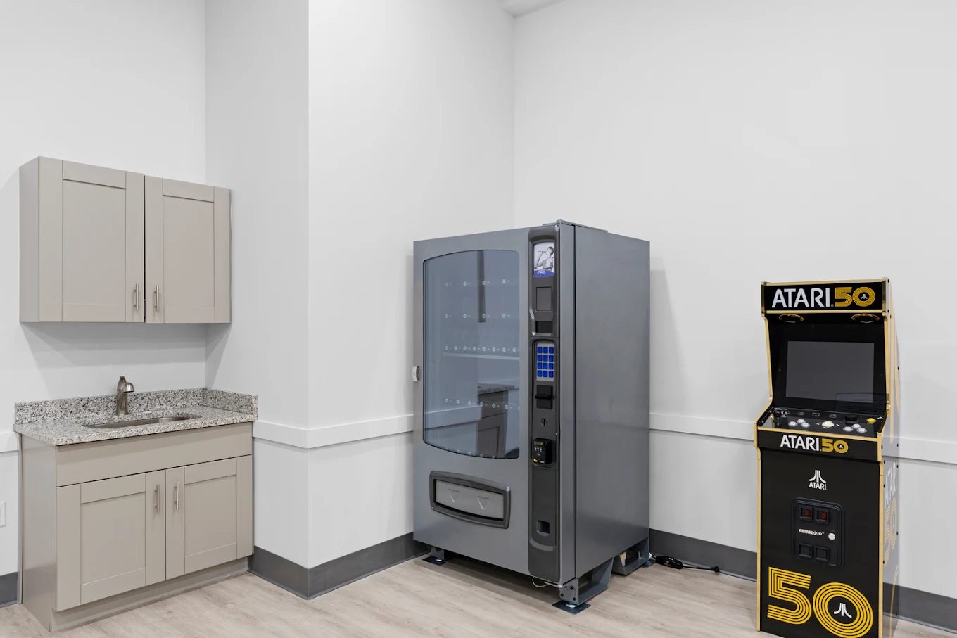 Corner with vending machine, sink, and retro arcade game