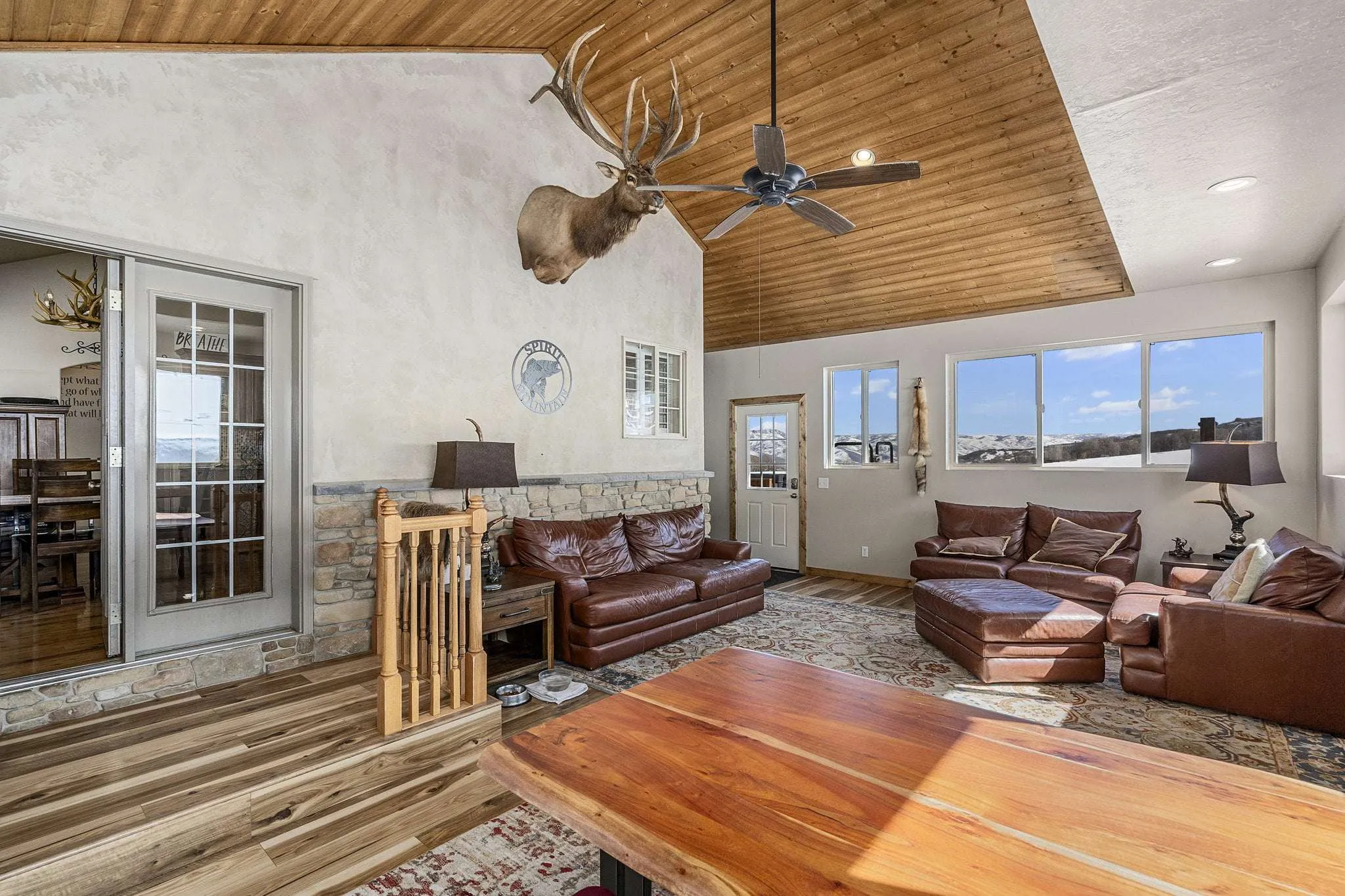 Bright lounge with brown sofas and wood-paneled ceiling