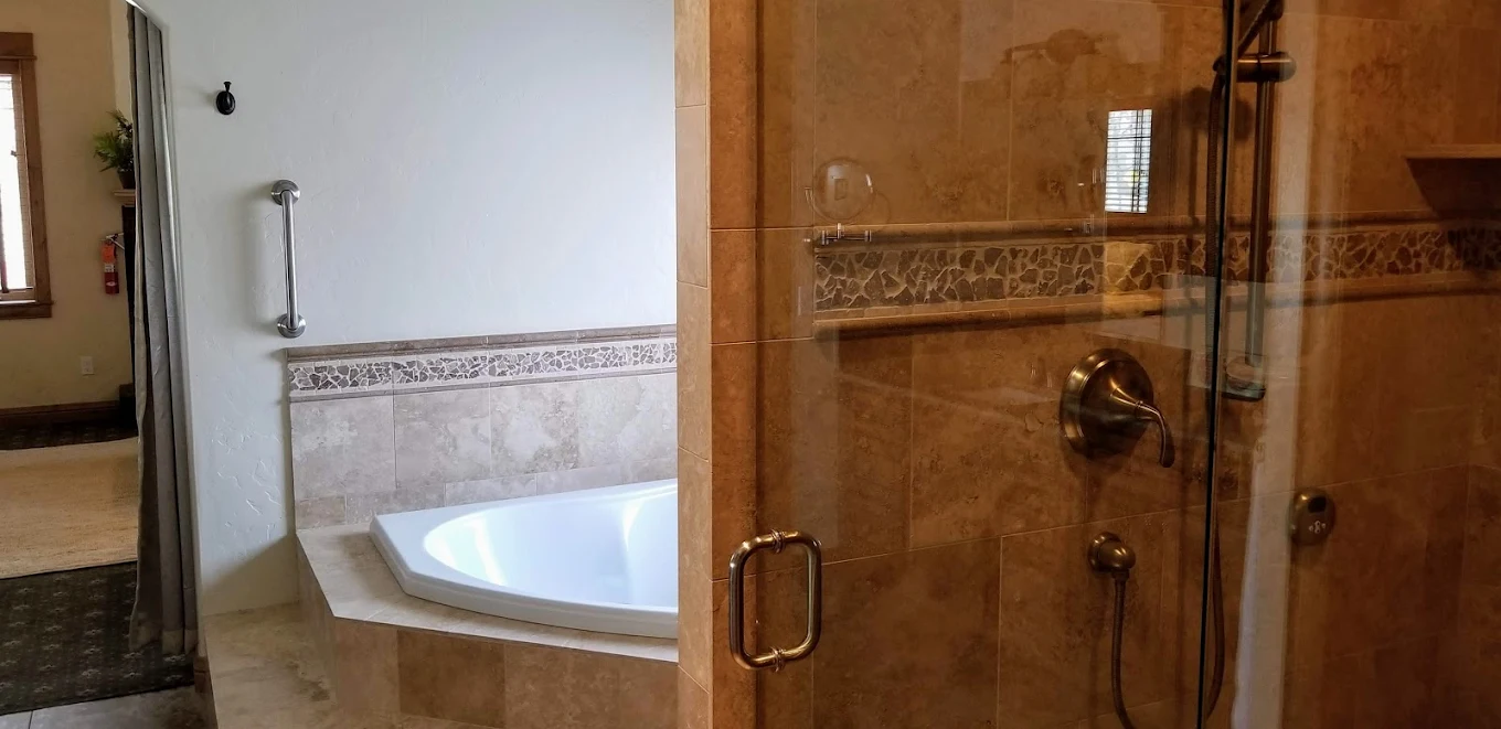 Tiled shower and built-in soaking tub with grab bar