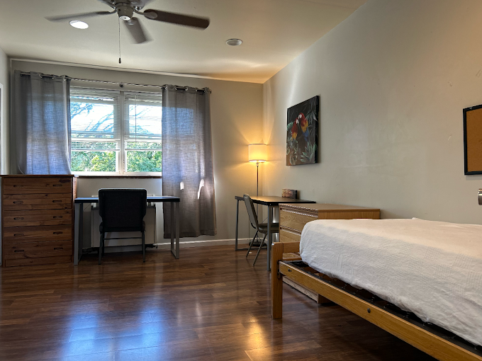 Sunlit bedroom with wood floors and desk setup