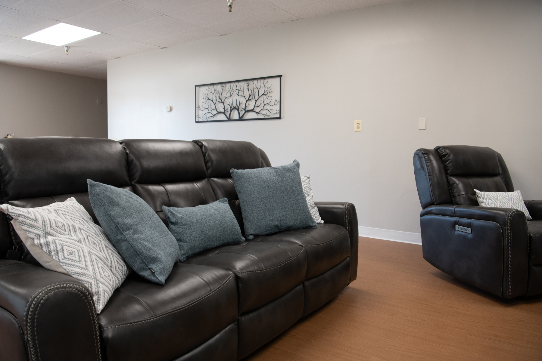 Black leather sofa and recliner with accent pillows