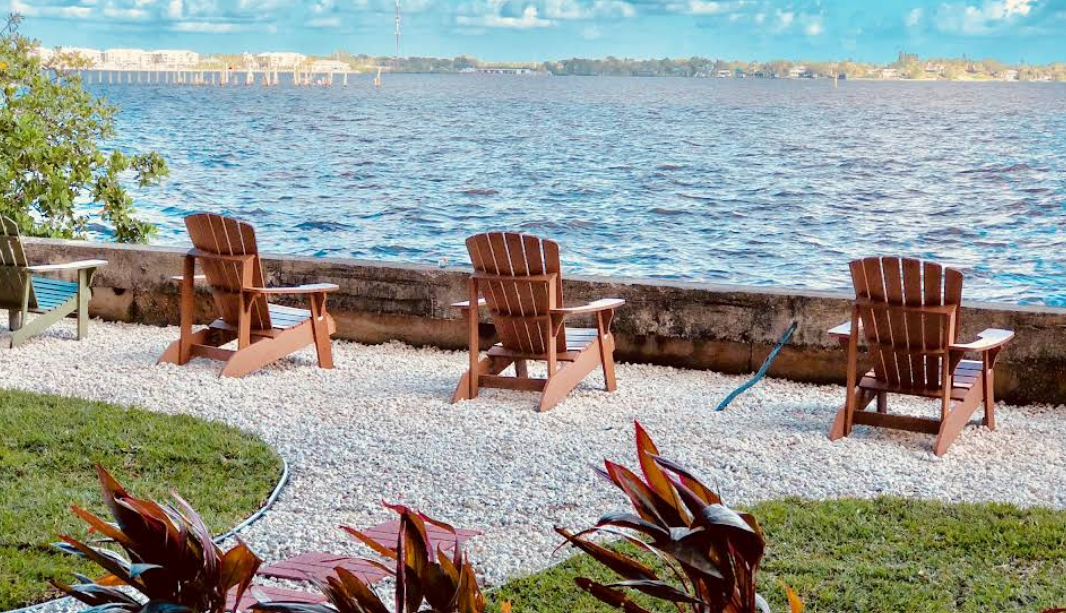 Adirondack chairs overlooking calm waterfront scene