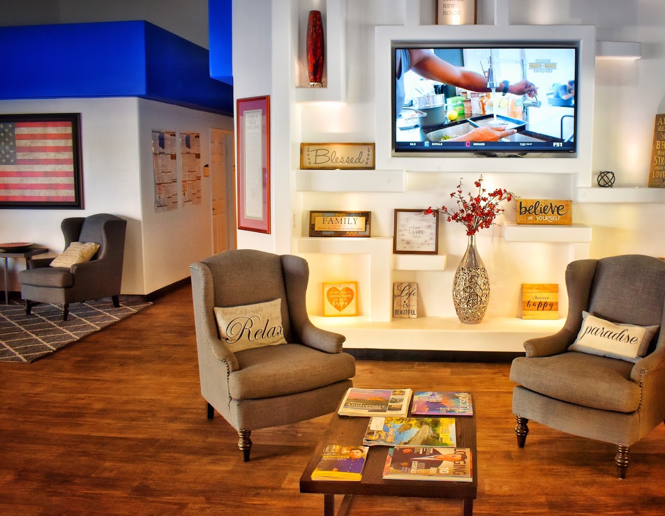 Lounge with chairs and a mounted TV.