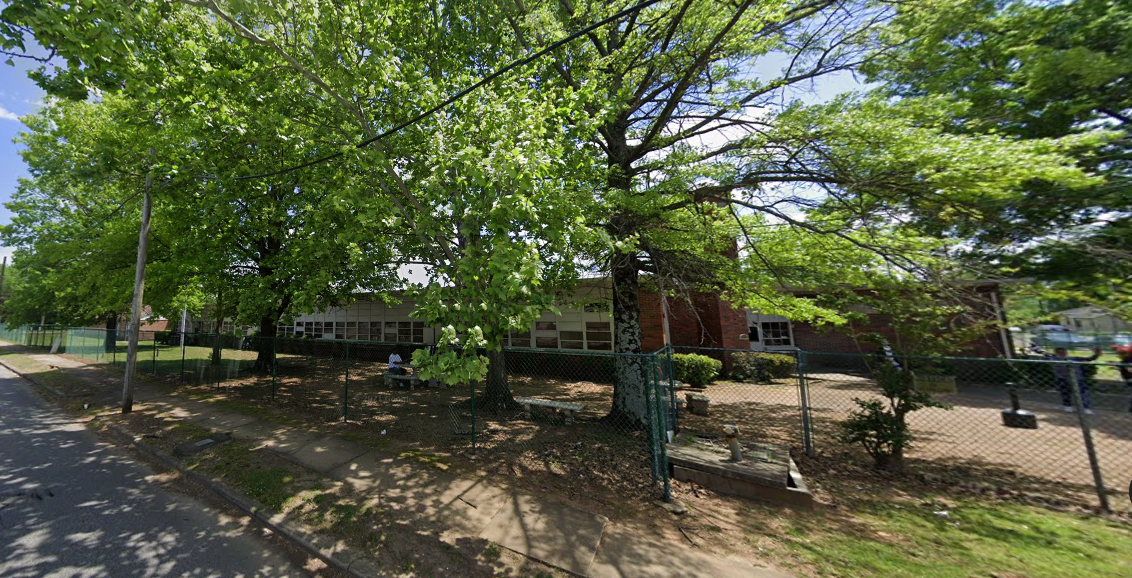 Brick rehab facility with shaded yard and surrounding trees