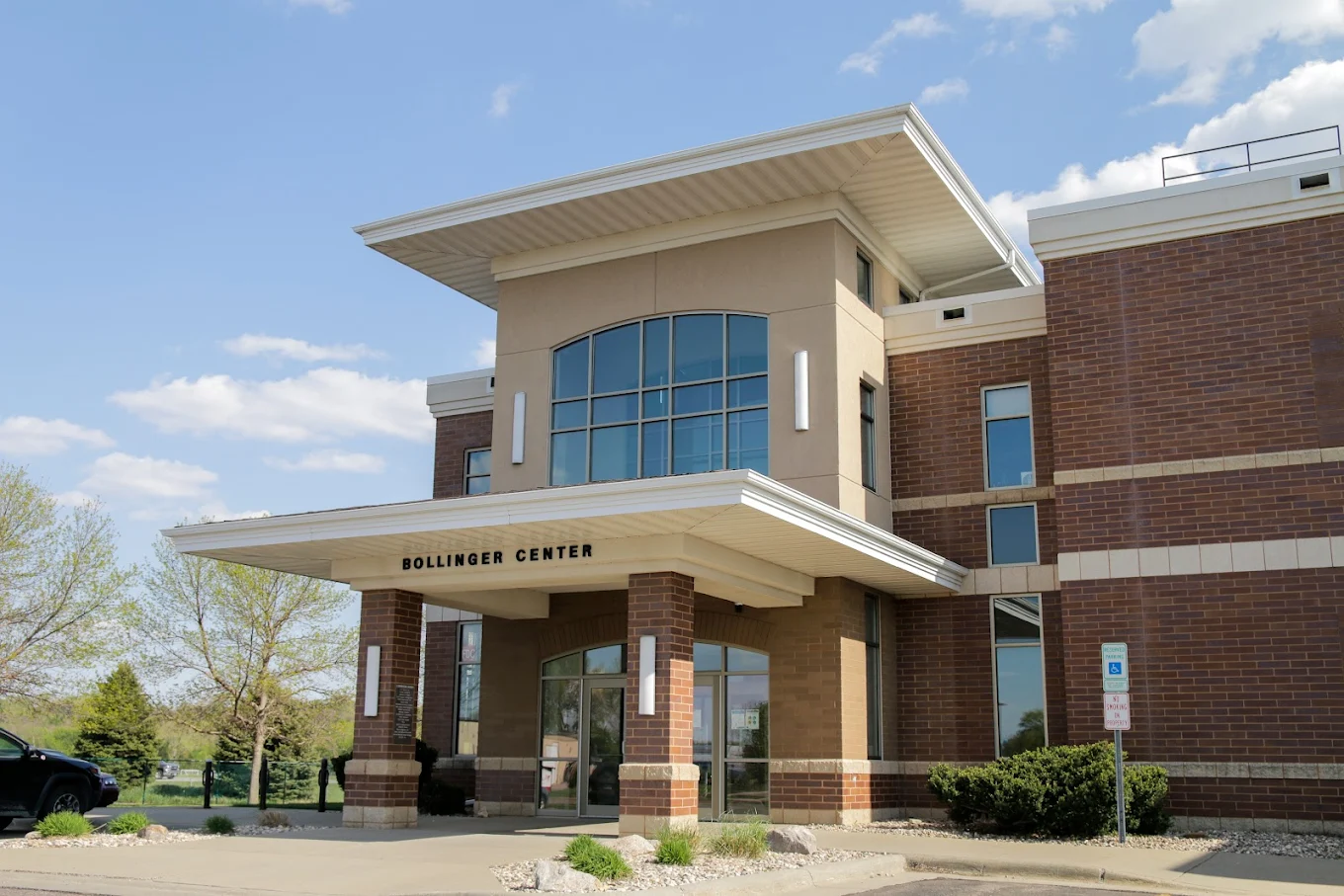 Modern brick building with Bollinger Center sign and glass entry