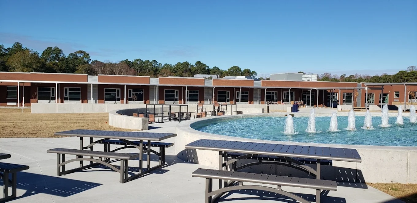 Outdoor pool with picnic tables and seating areas