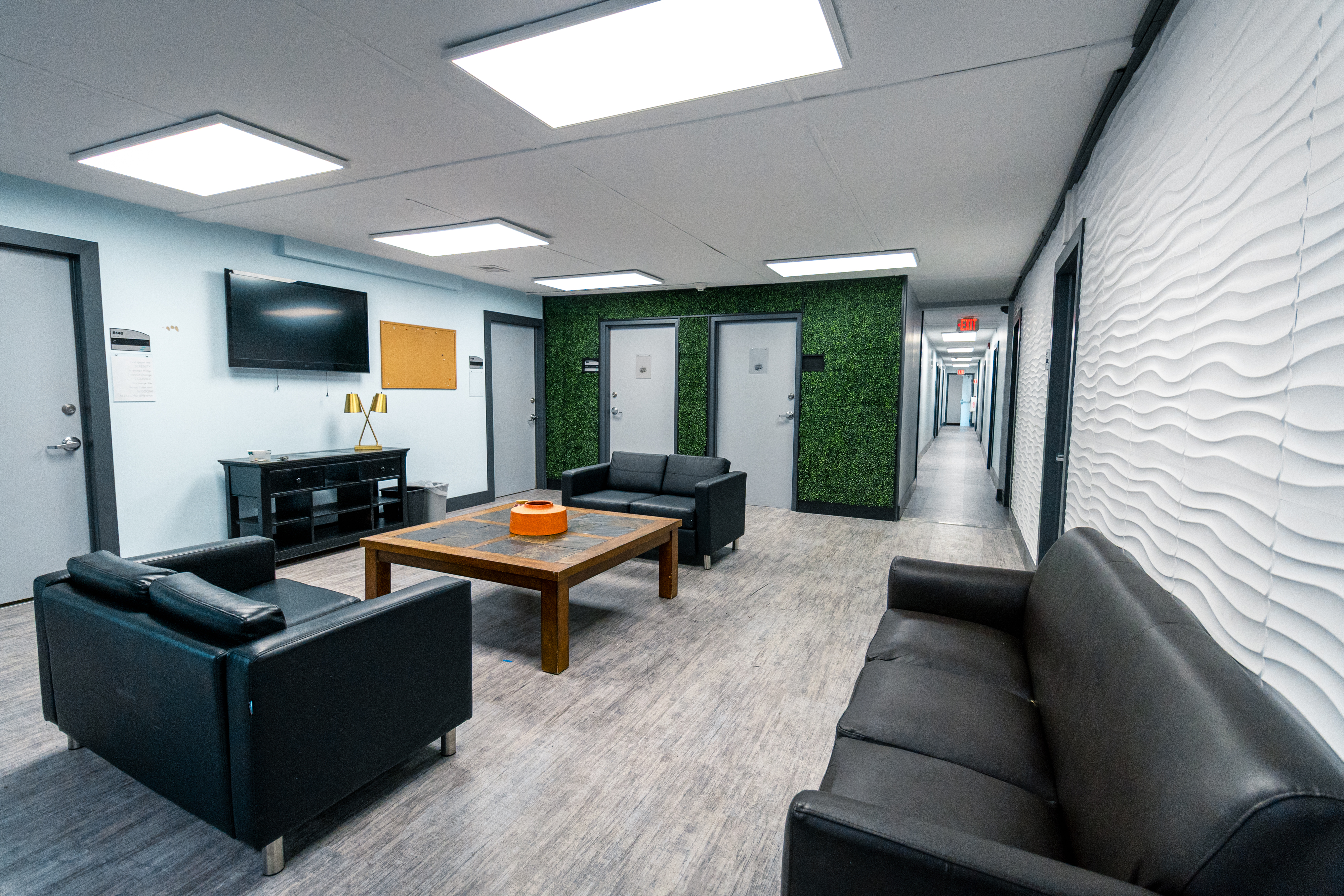 Another view of a shared lounge space with seating and neutral décor.