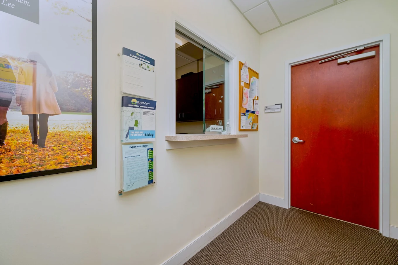 Check-in window beside a red door and patient information