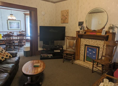 Cozy lounge with TV, fireplace, and wooden chairs