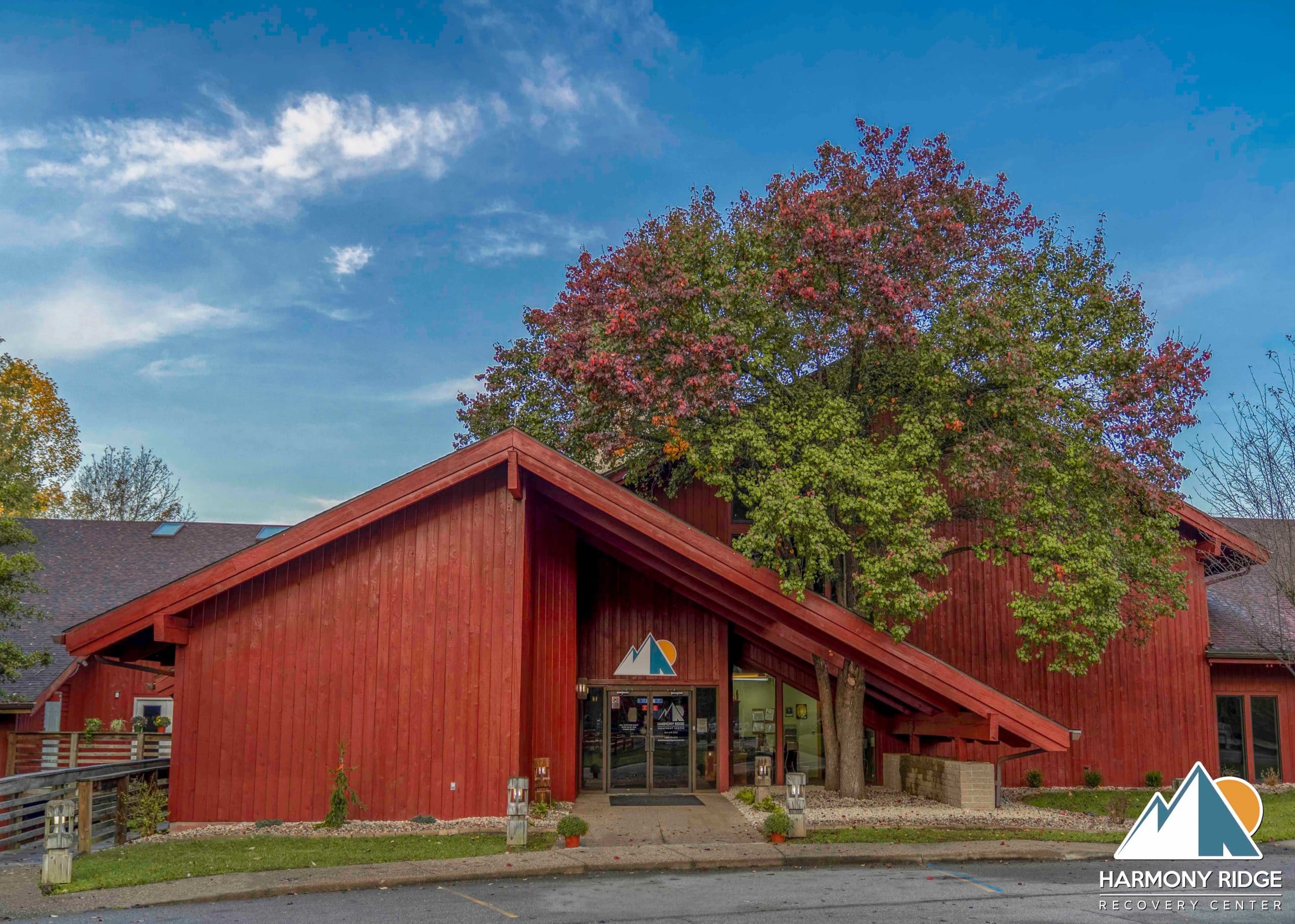 Entrance of a red building with a large tree in front