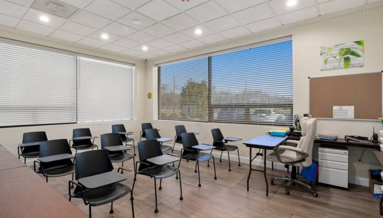 Classroom with chairs, desks, and large windows for daylight