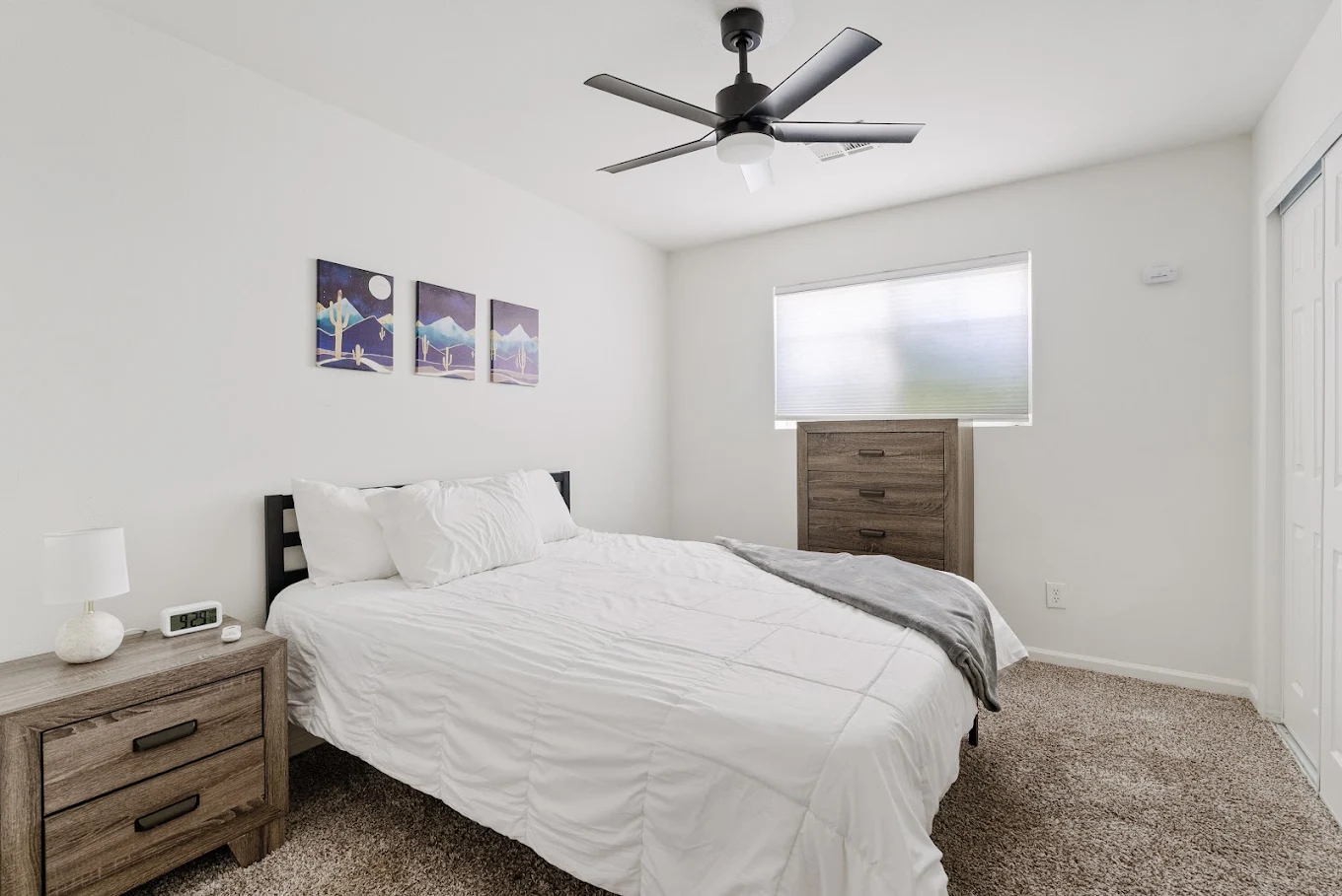 Private bedroom with white bed, nightstands, and ceiling fan