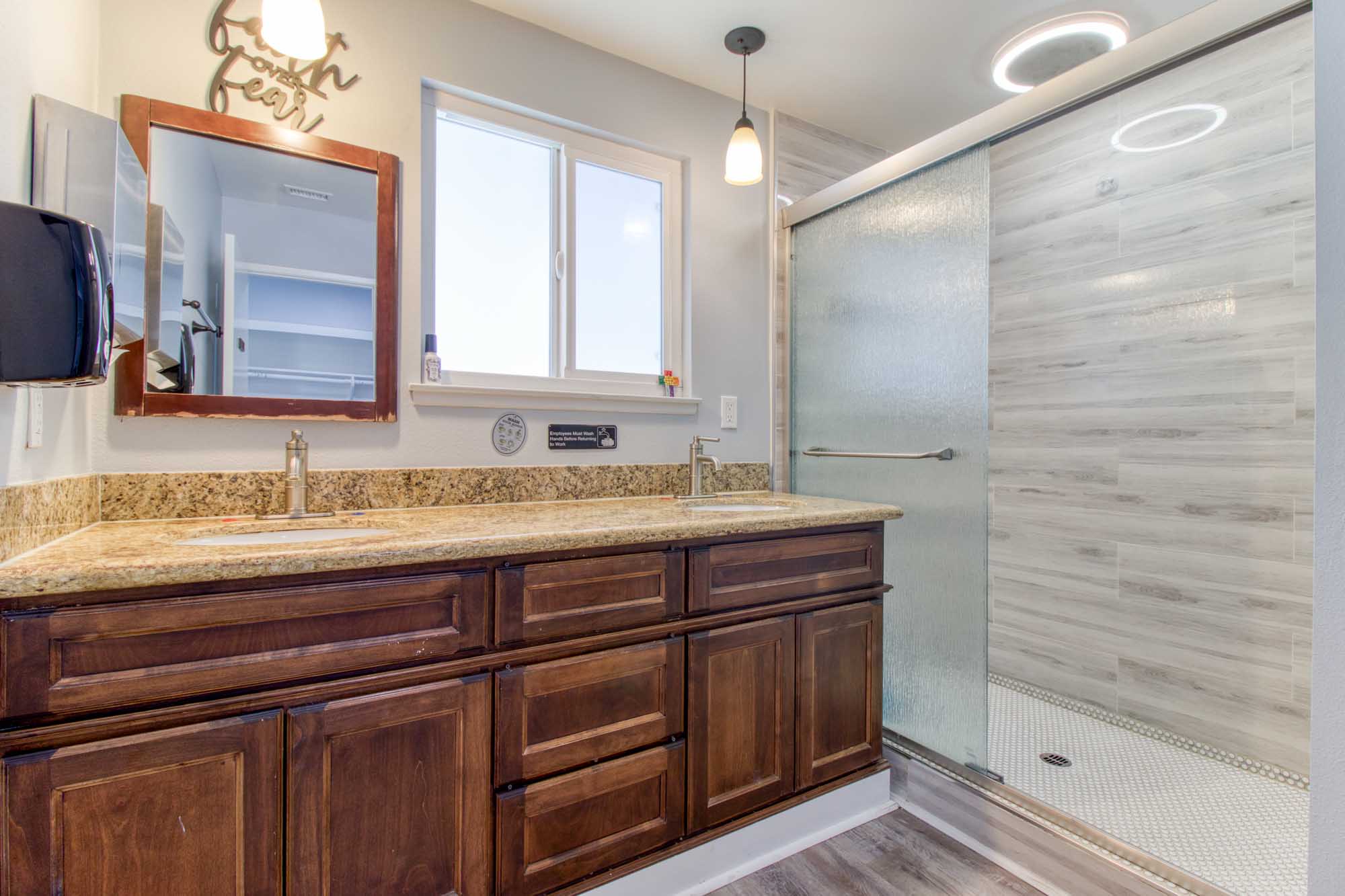 Bathroom with granite countertop and walk-in glass shower