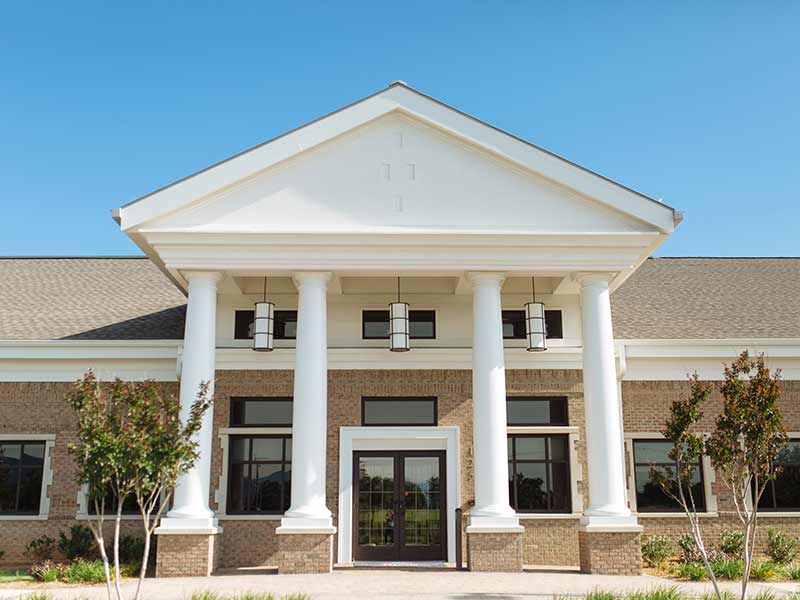 Brick facility entrance with white columns and double doors