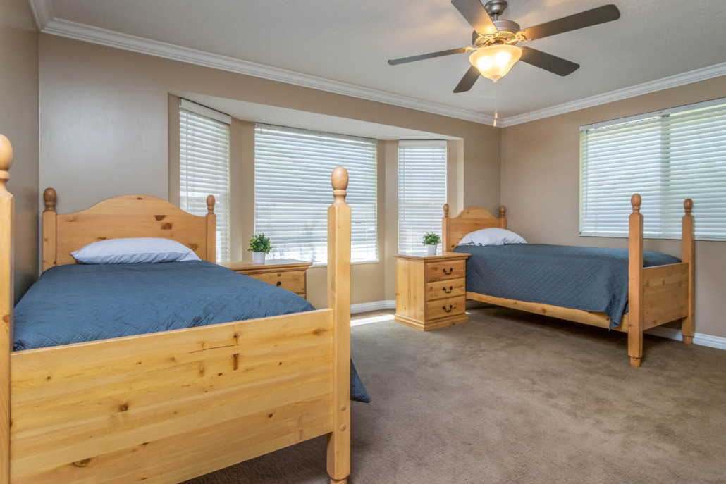 Shared bedroom with twin beds and large windows