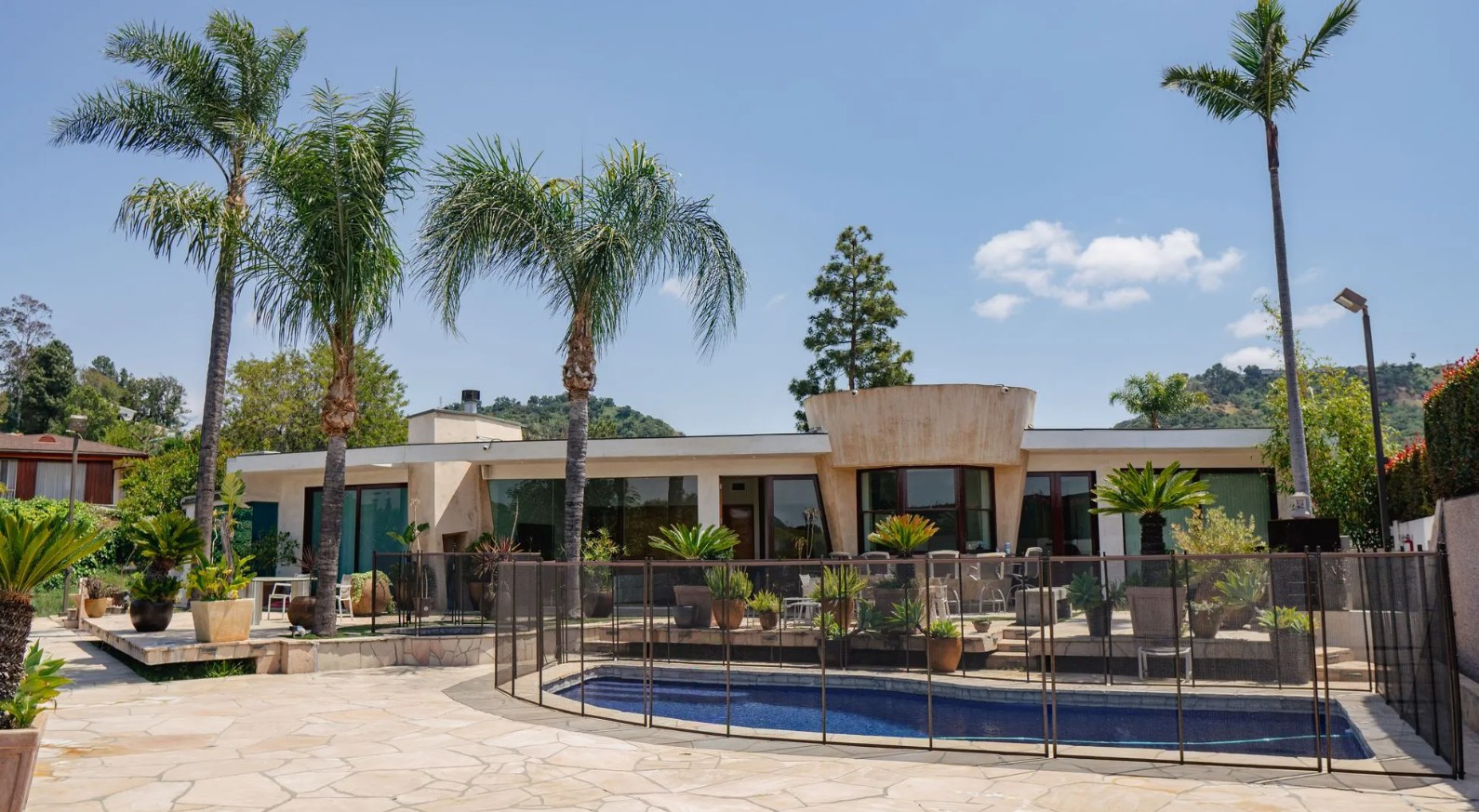 Pool courtyard with fenced pool and palm trees