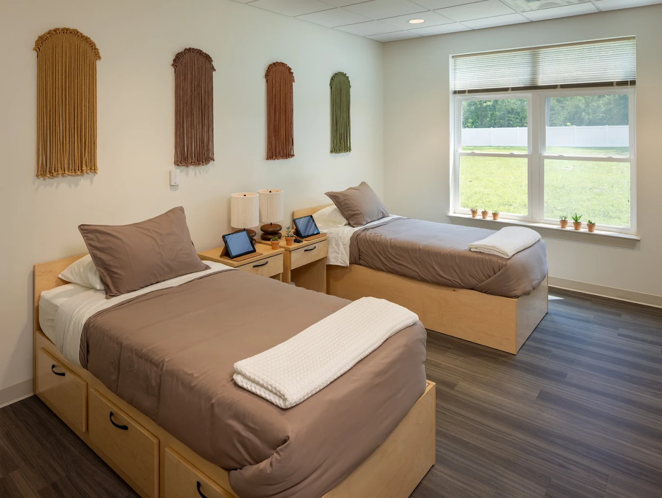 Shared bedroom with two twin beds, bedside tables, and large window.