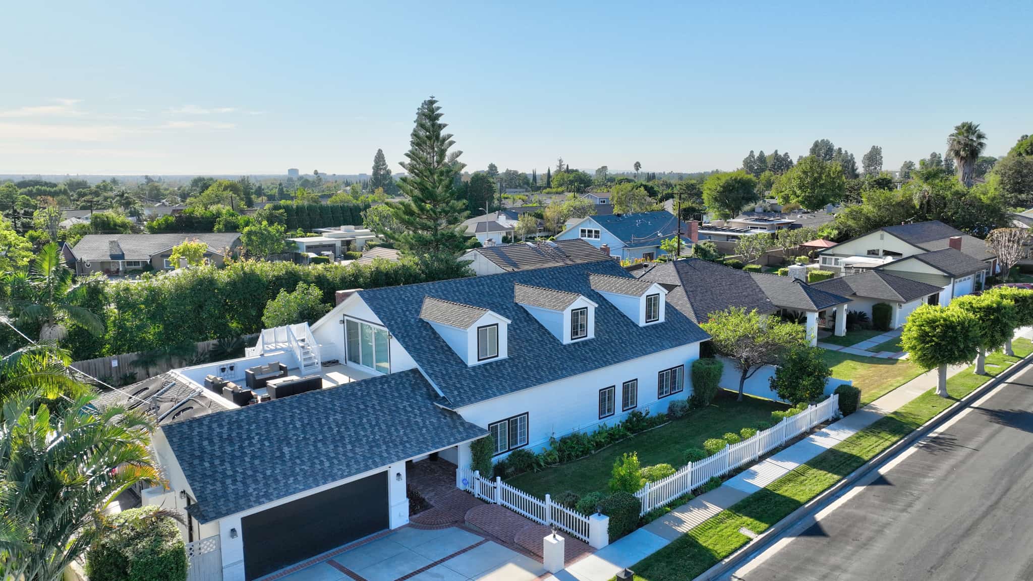 Aerial view of Opus Health Costa Mesa with landscaped yard and white fence.