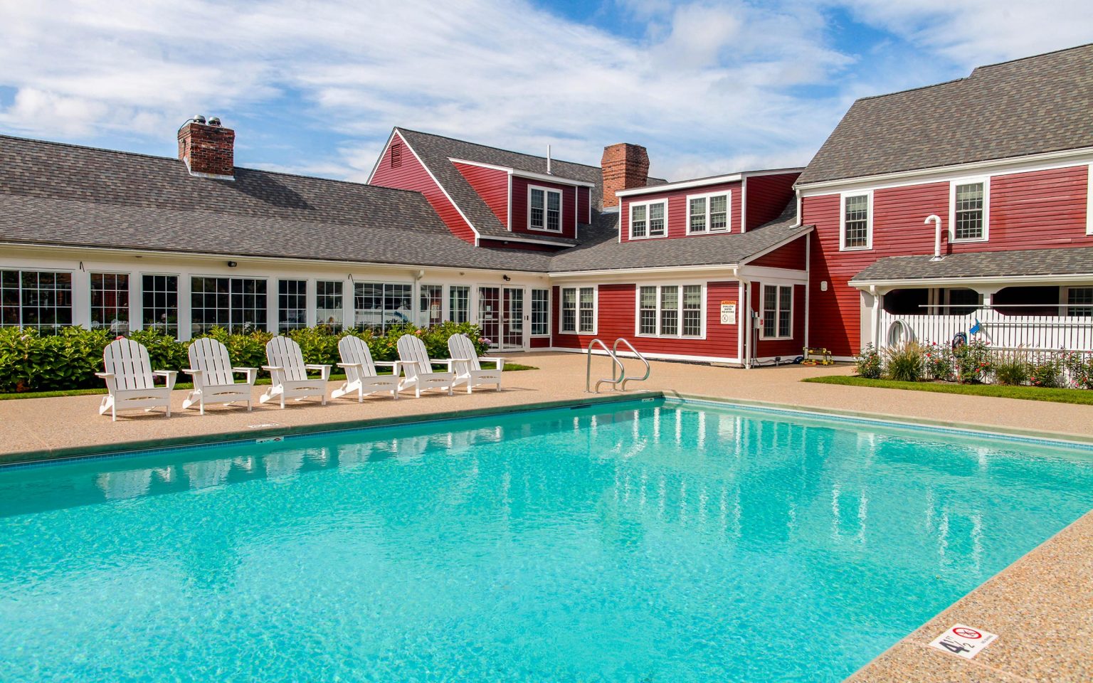 Pool area with chairs lined up next to it.