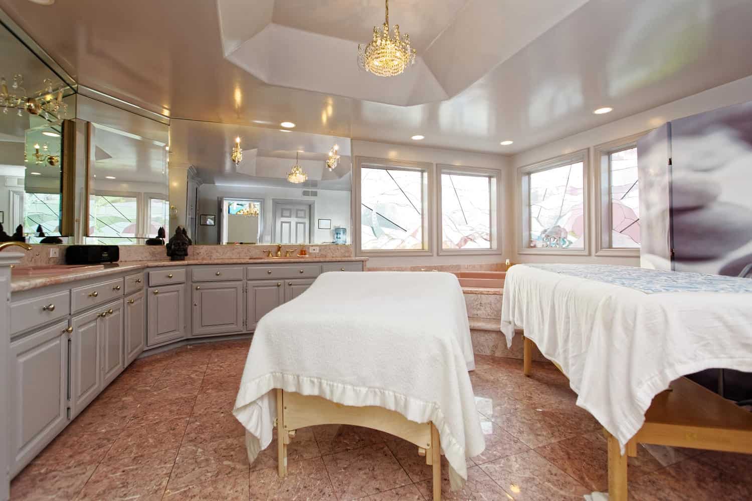 Spa room with two massage tables and chandeliers