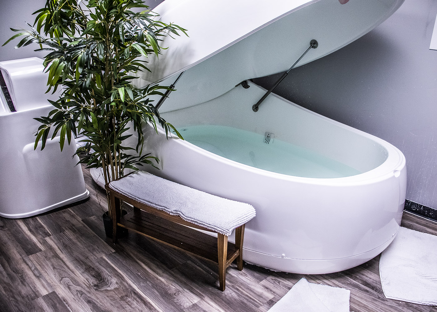 White float pod half-open in a serene, spa-like room
