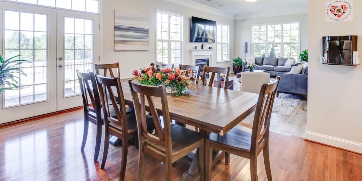 Bright dining room with large wooden table and double glass doors