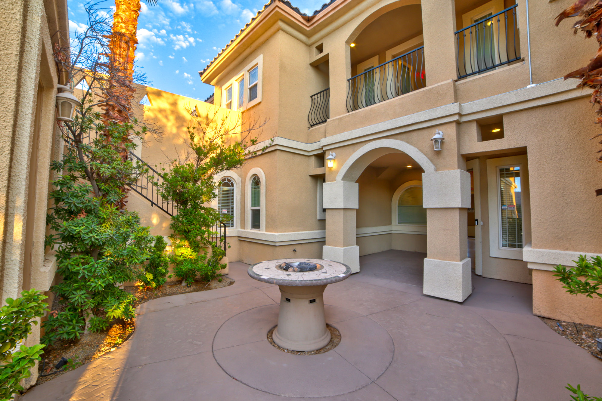 Courtyard with arched entrances and a fire pit.
