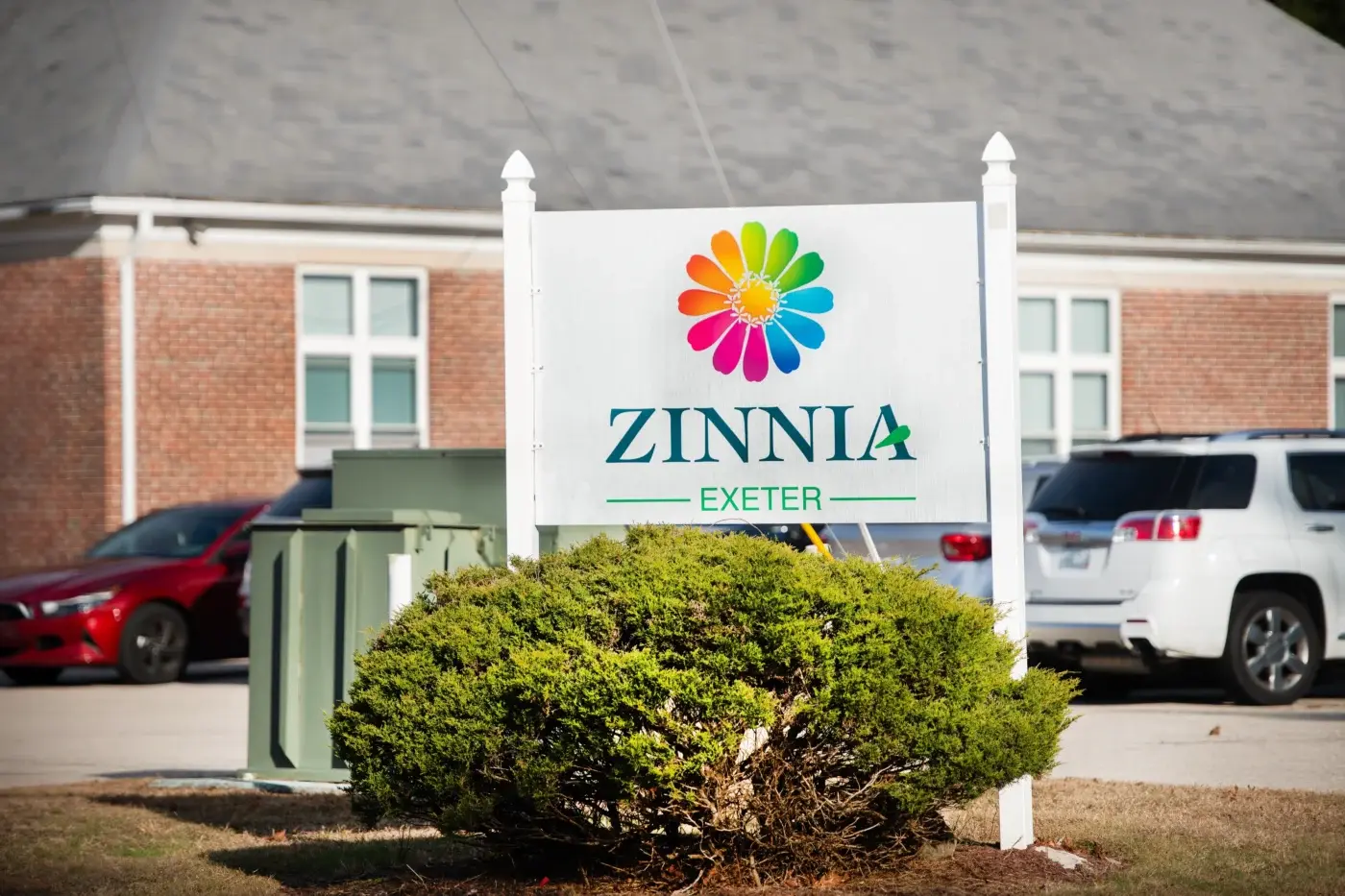 Zinnia Exeter sign in front of a brick building