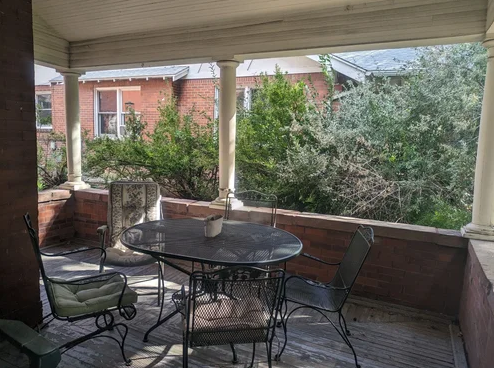 Covered porch with patio table and chairs