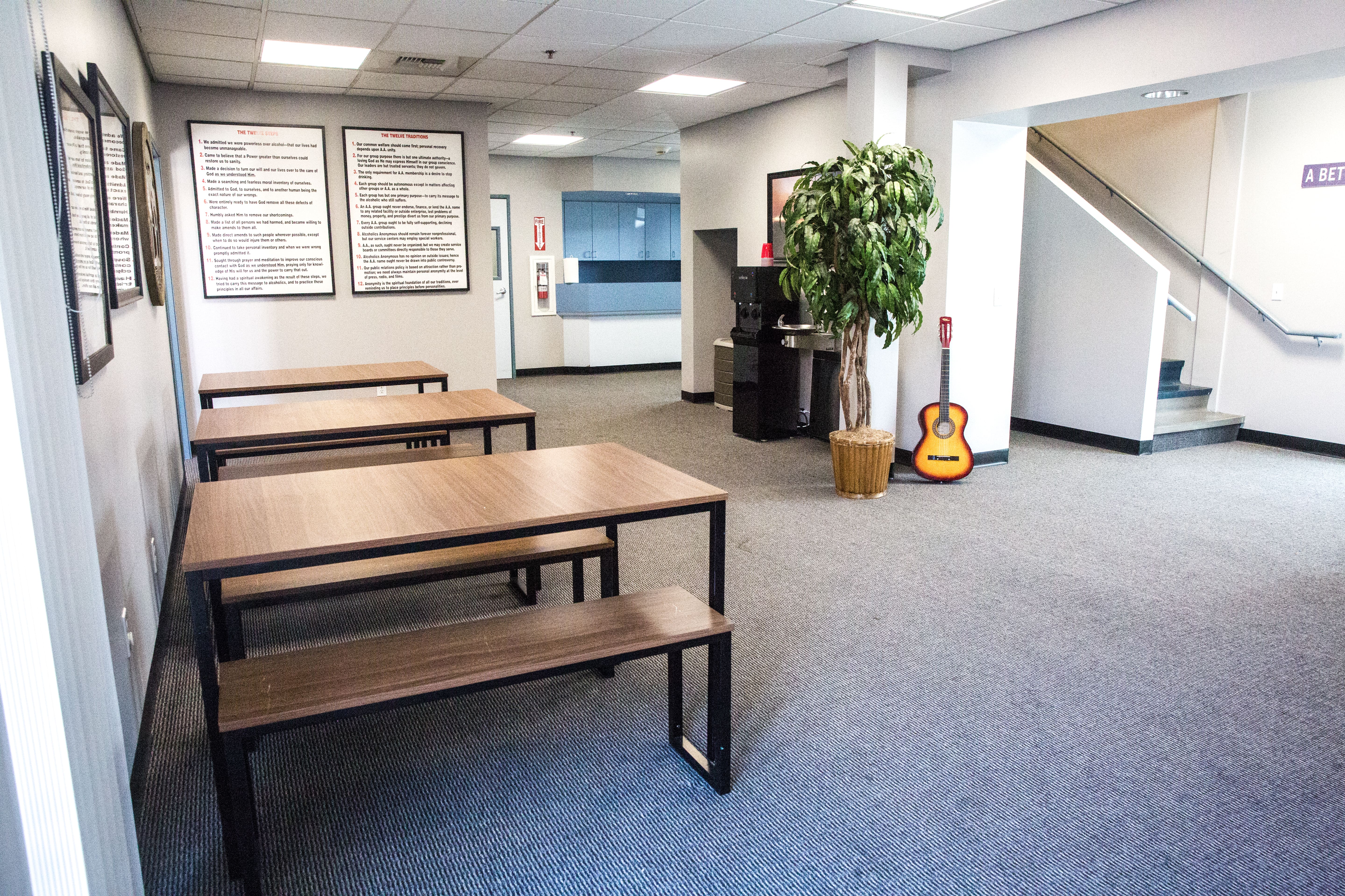 Dining tables and guitar in open indoor lounge