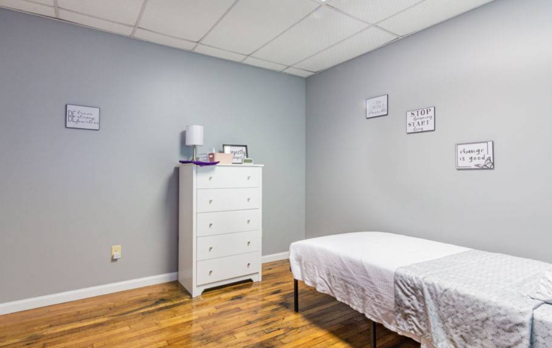 Private bedroom with bed, dresser, and hardwood floors