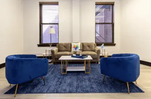 Cozy seating area with blue chairs and large windows