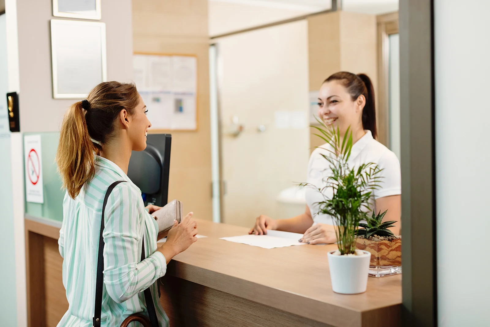 Patient checking in at treatment center reception desk