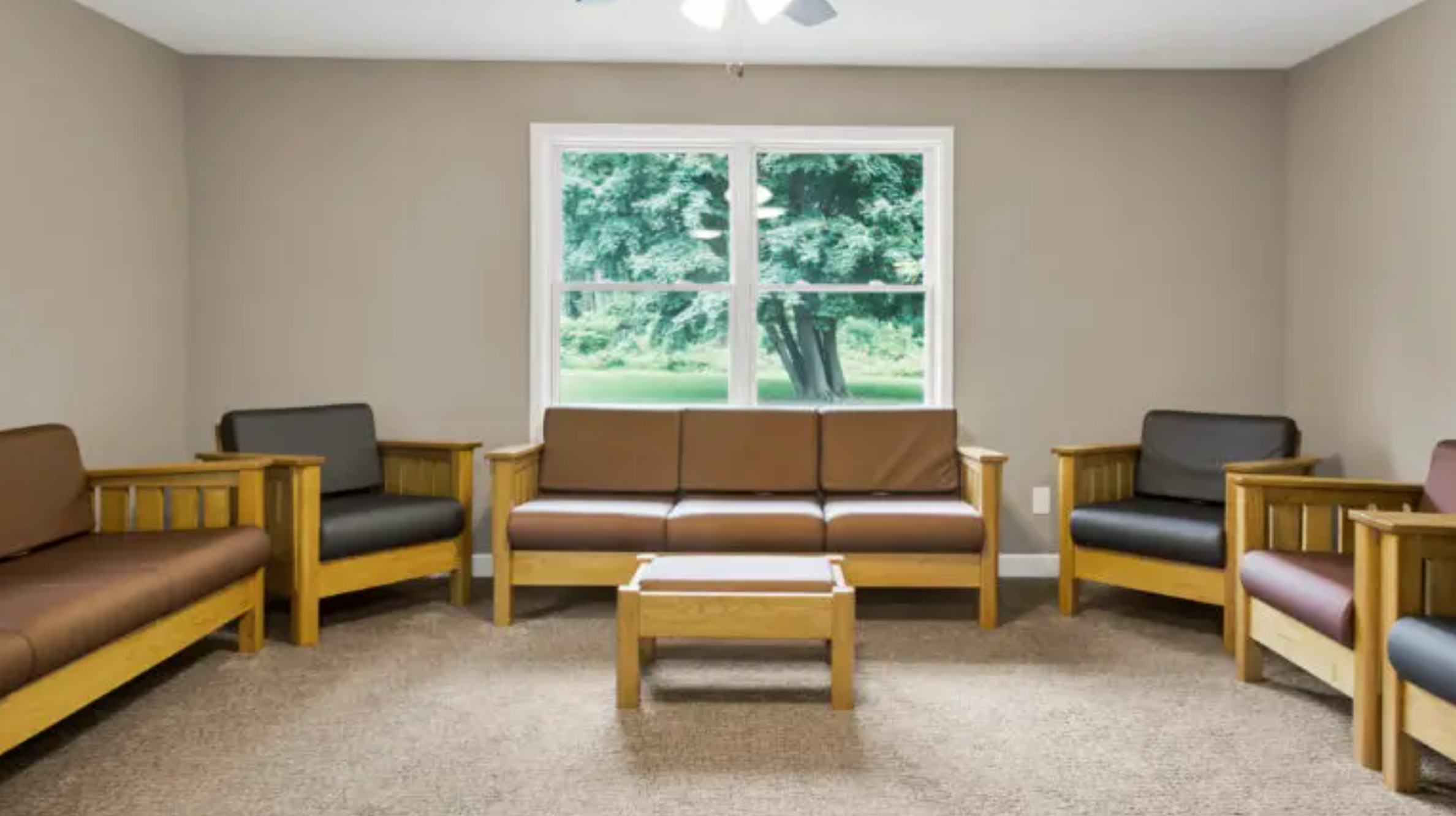 Group therapy room with sofas and chairs in a recovery center.