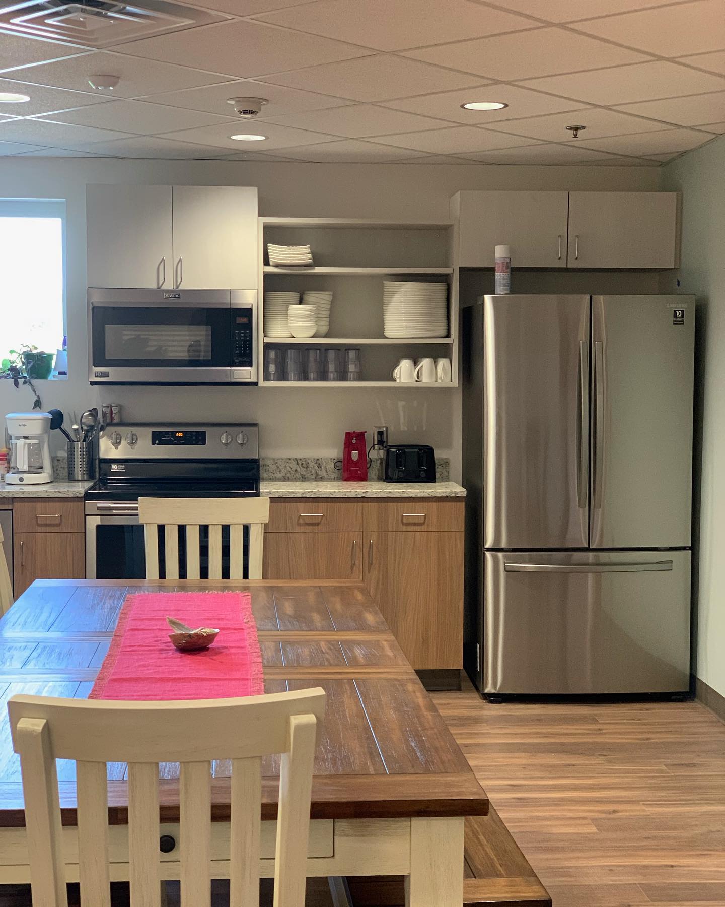 Shared kitchen with stainless appliances and wooden dining table