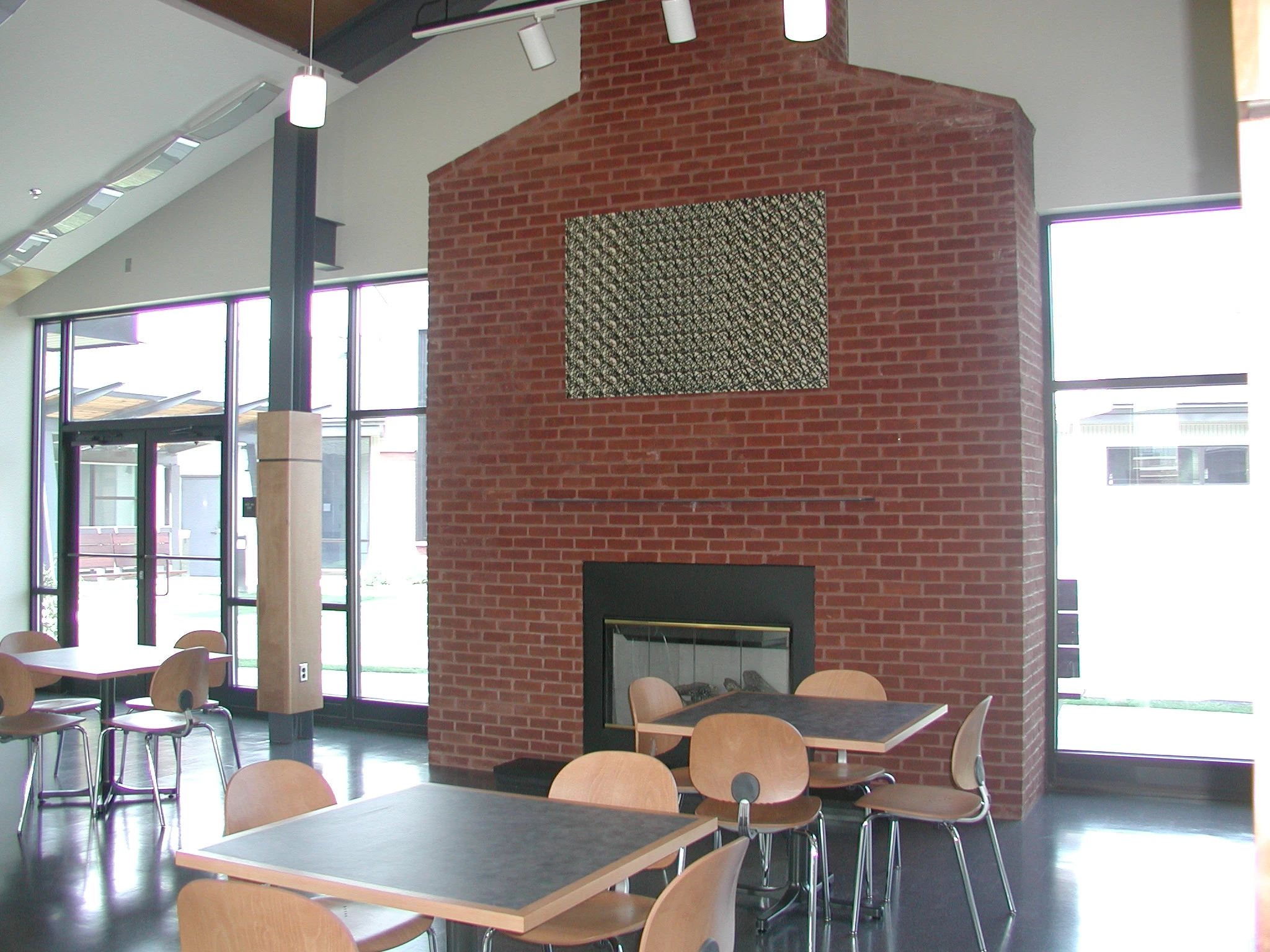 Rehab dining room with red brick fireplace and modern tables