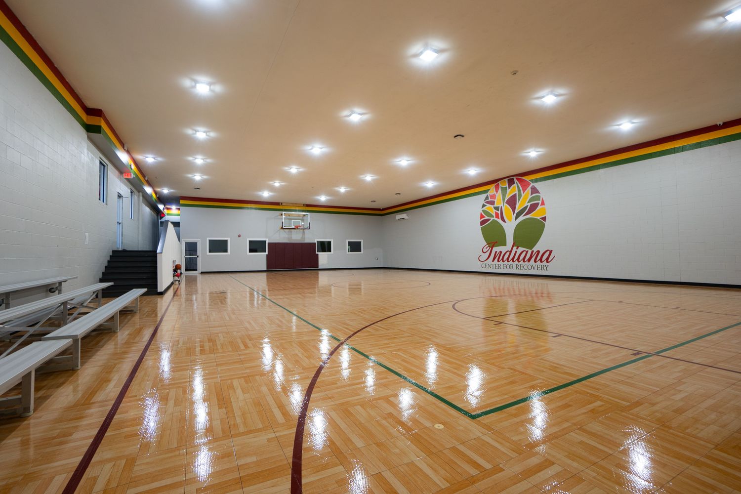 Bright indoor basketball court with polished wood flooring.