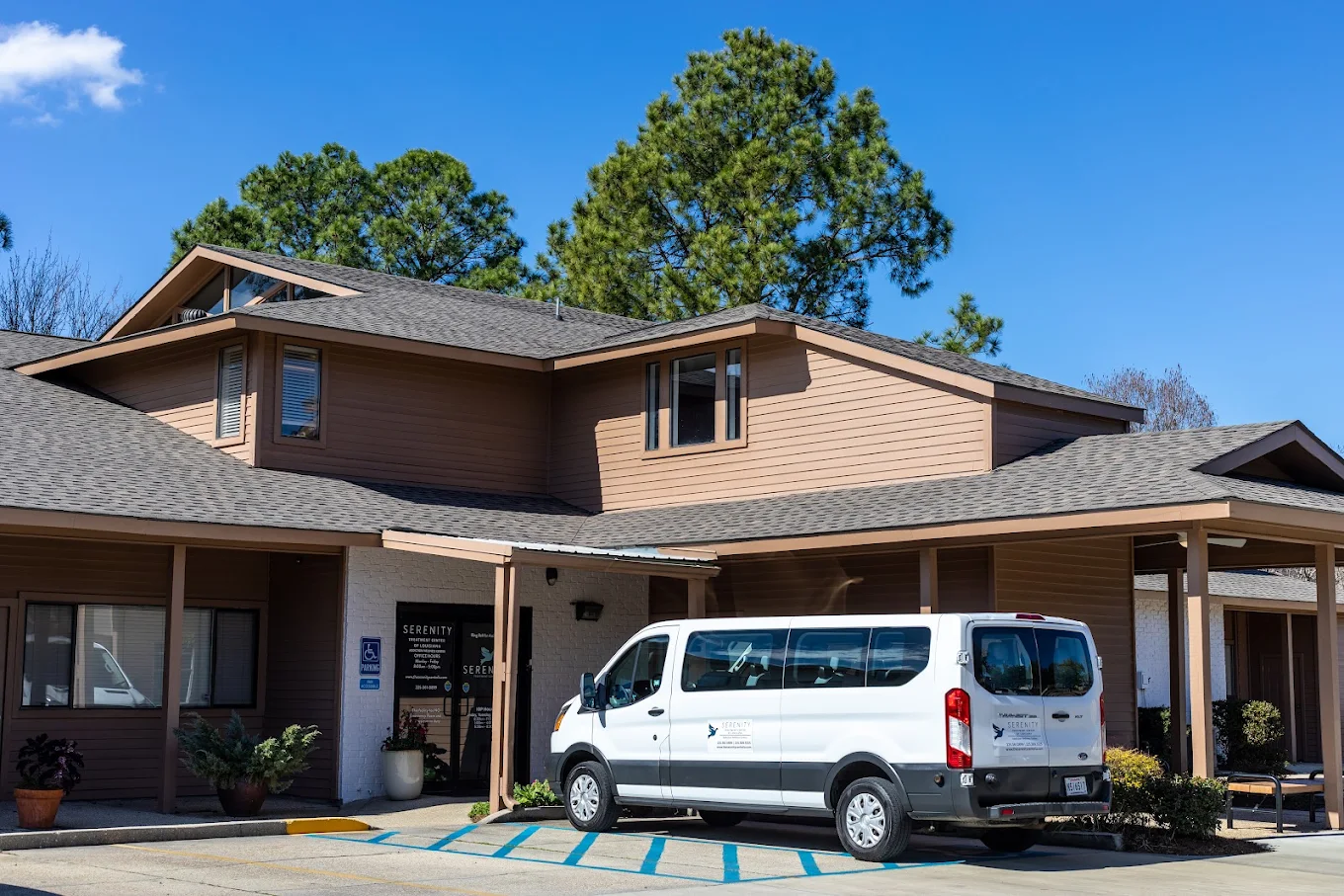 Red brick rehab facility with green shutters and front lawn